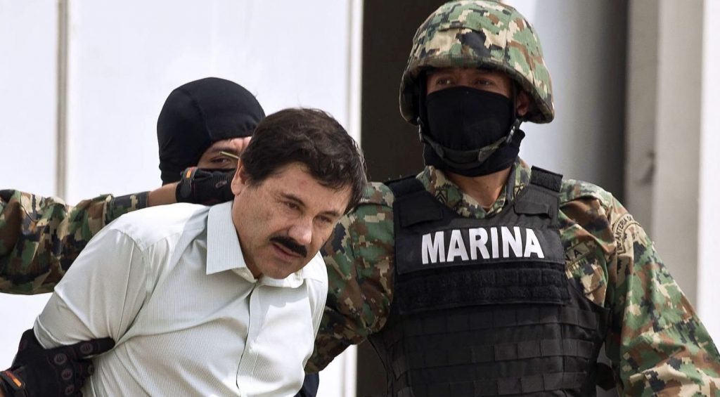 Drug trafficker Joaquin "El Chapo" Guzman is escorted to a helicopter by Mexican security forces
